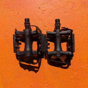 A pair of metal bicycle pedals in Style 7 design, featuring a sleek, modern look with textured surfaces for grip.