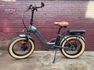 A black custom folding electric bike with a 750-watt motor, shown in a folded position against a white background.