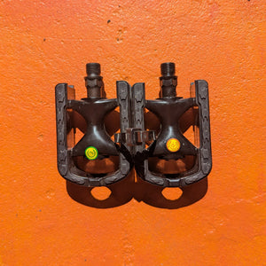 A pair of metal e-bike pedals in a modern, rugged style with a textured surface and open frame design for enhanced grip and durability.