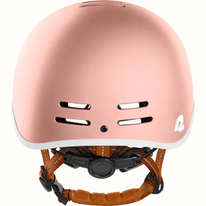 Rose gold Retrospec Remi eBike helmet, side view, with adjustable straps and ventilation holes, displayed on a white background.