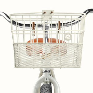 Retrospec Apollo steel bike basket in eggshell color attached to an eBike, shown from a side angle.