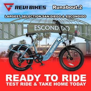 Electric bike in water blue color, side view, featuring a step-through frame and rear cargo rack, photographed against a plain background.