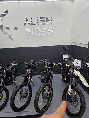 Side view of a 2025 Surron Ultra Bee 21kW electric dirt bike in black and yellow, displayed on a white background.