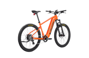 A side view of the Velotric Summit 1 eBike in a natural outdoor setting, showcasing its sturdy frame, front suspension fork, and thick all-terrain tires.