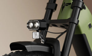 Electric bicycle ENGWE E26 3.0 in black, side view, parked outdoors on a paved path with greenery in the background.