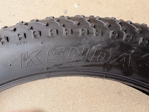 A black eBike with 26x4 inch Kenda Juggernaut fat tires, shown in a side profile against a white background.