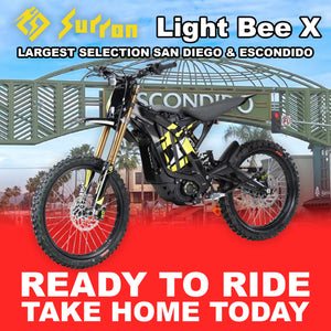 Black Sur-Ron Light Bee X eMOTO electric bike, model R2R, side view, outdoors.