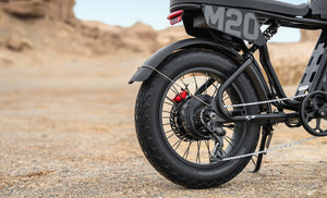 Engwe M20 3.0 electric bike in black, shown from a side angle with thick tires, dual headlights, and a sturdy frame, displayed outdoors on a paved surface.