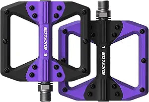 Purple and black bicycle pedals with a textured surface, shown on a white background.