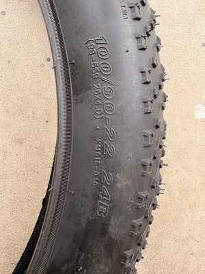 A black eBike with 26x4 inch Kenda Juggernaut fat tires, shown in a side profile against a white background.