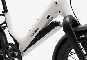 Side view of the Urtopia Carbon Joy Ultra eBike in Creme color, showcasing its sleek carbon frame, integrated battery, and modern design against a plain background.