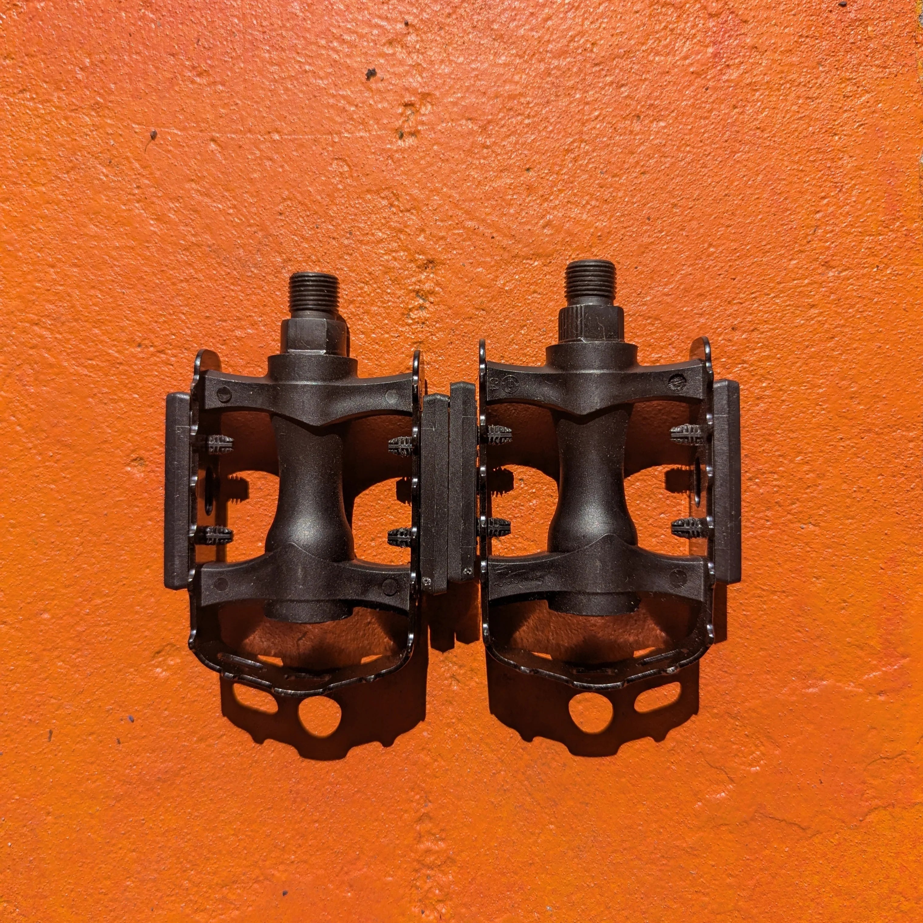 A pair of metal bicycle pedals in Style 5 design, featuring a sleek, durable construction with textured surfaces for improved grip.