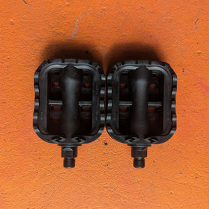 Close-up of metal eBike pedals in a beach cruiser style, showing textured surface and sturdy construction.