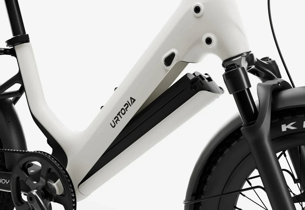 Side view of the Urtopia Carbon Joy eBike in a modern urban setting, showcasing its lightweight carbon frame, sleek design, and integrated display.