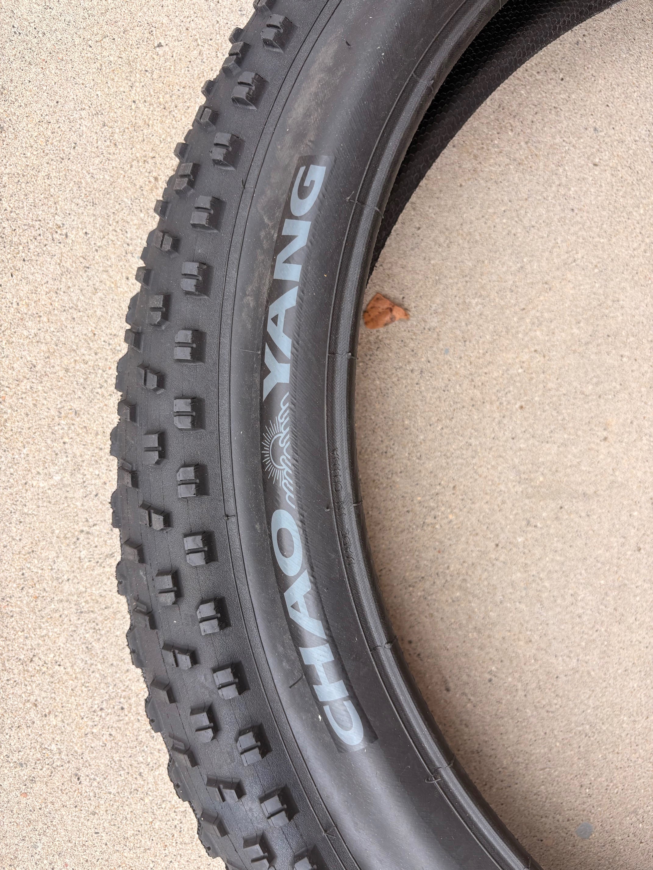 A black eBike with 26x4 inch Chao Yang fat tires, shown from a side angle against a white background.