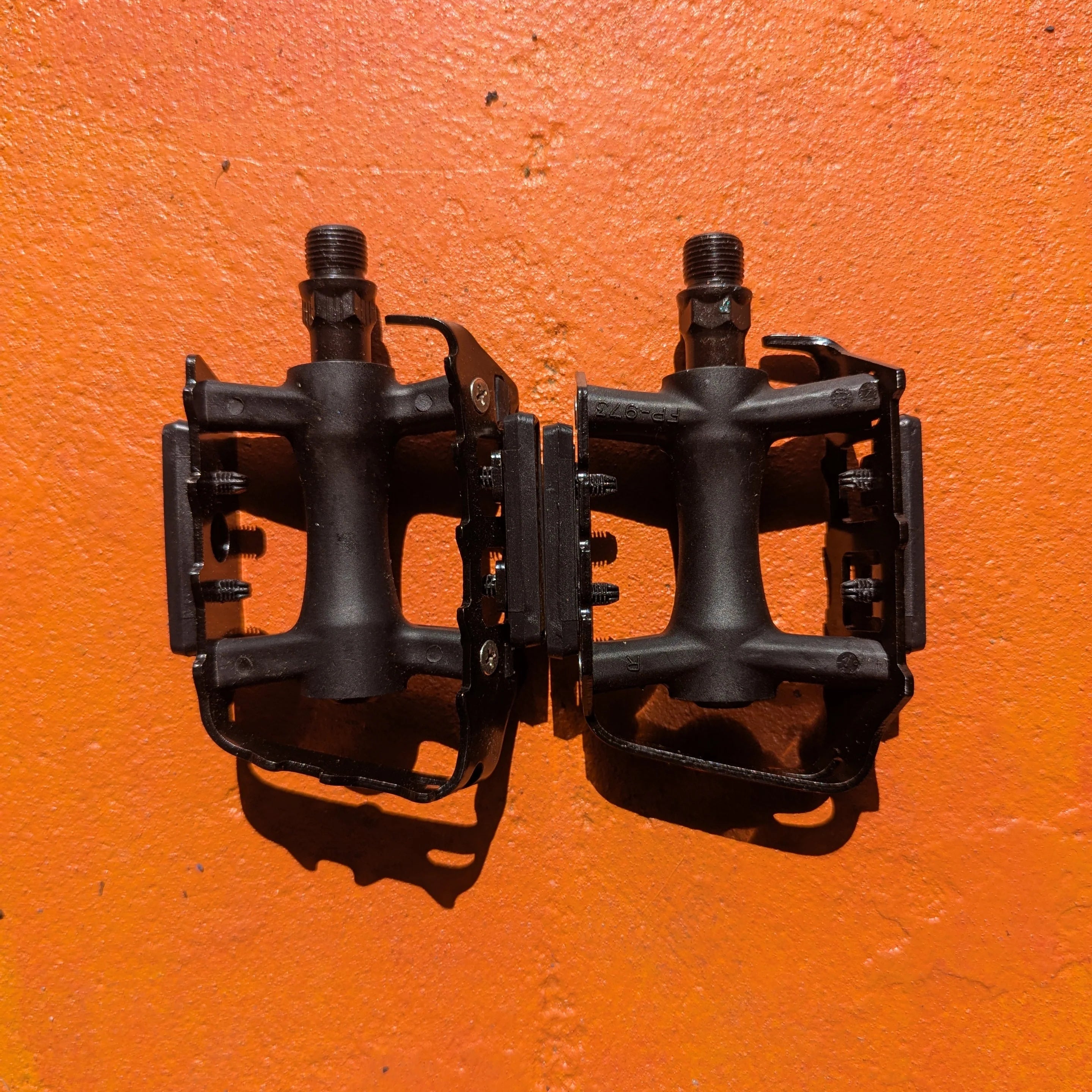 Close-up of metal e-bike pedals in a modern, rugged style, featuring a textured surface and durable construction.