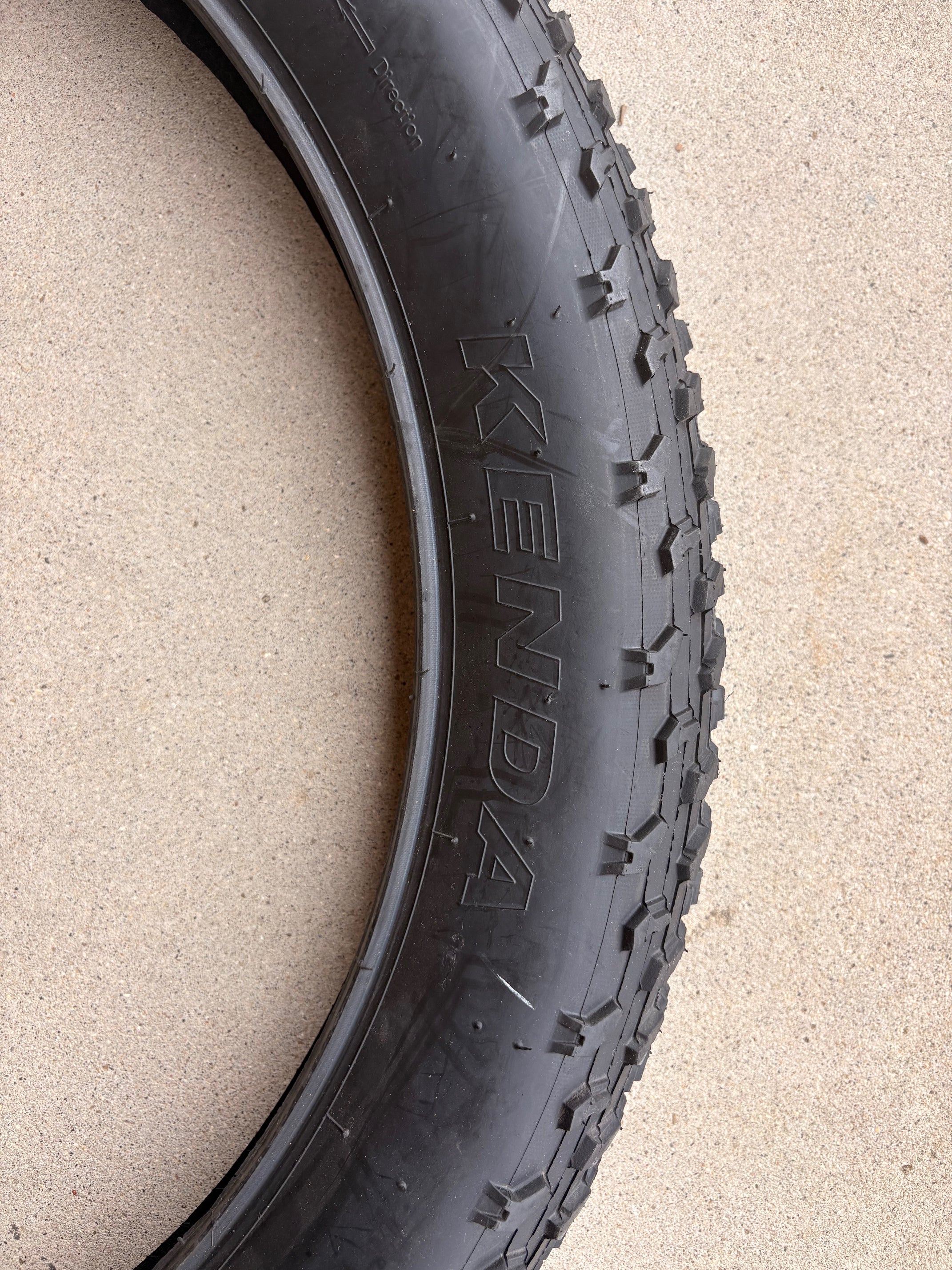 A black eBike with 26x4 inch Kenda Krusade fat tires, shown in a side profile against a white background.