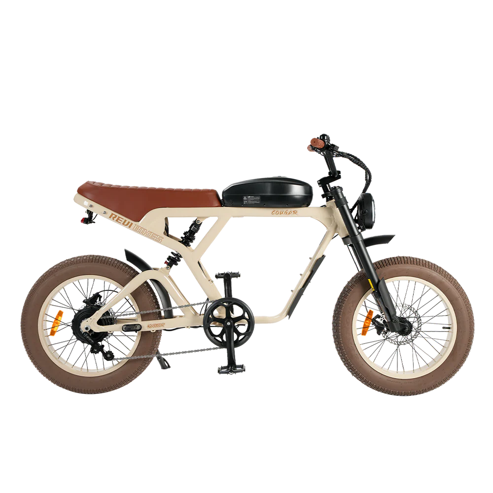 A sand-colored eBike Revi Cougar electric bicycle shown from the side, highlighting its frame, wheels, and battery.