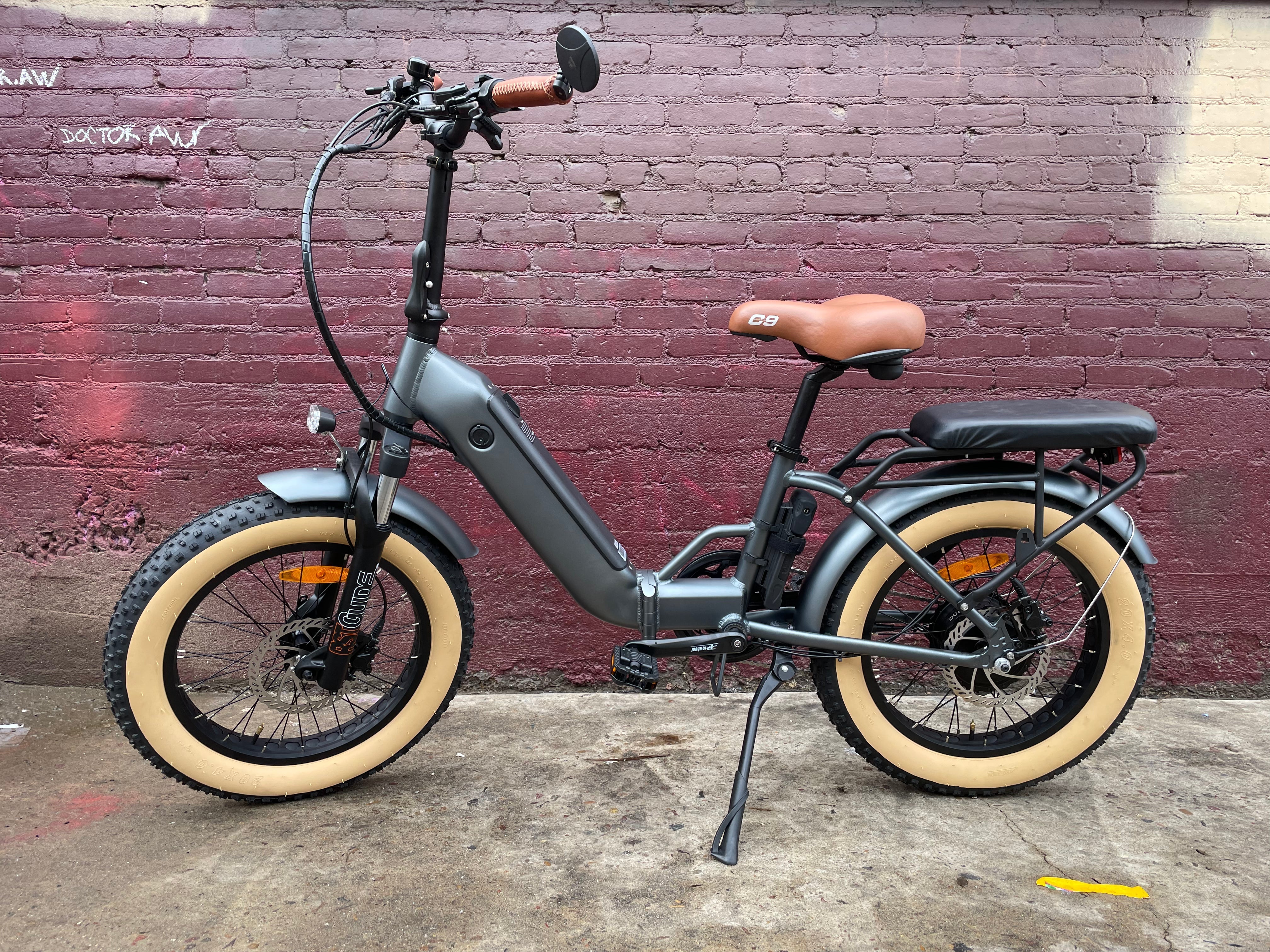 A black custom folding electric bike with a 750-watt motor, shown in a folded position against a white background.