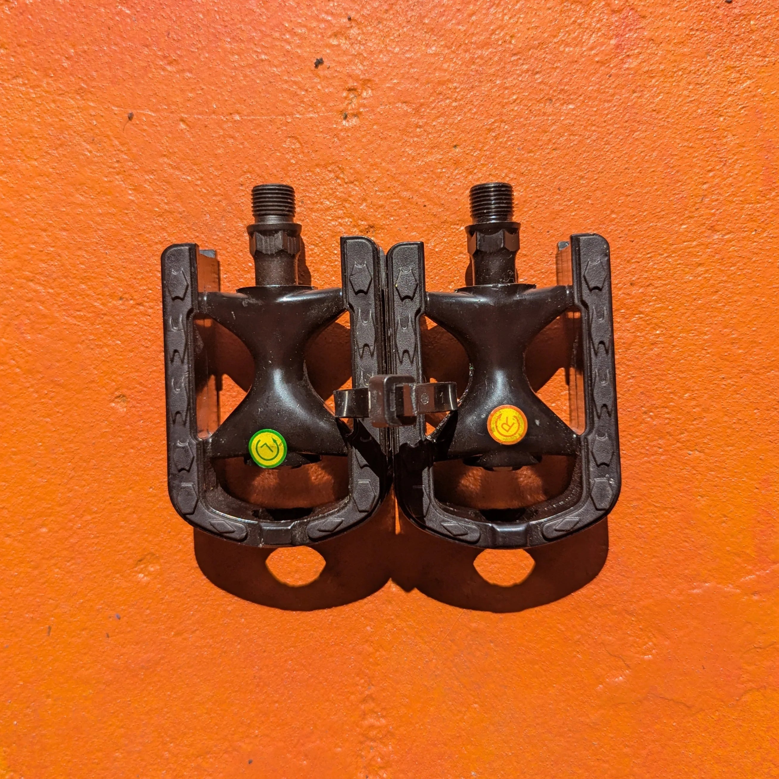 A pair of metal e-bike pedals in a modern, rugged style with a textured surface and open frame design for enhanced grip and durability.
