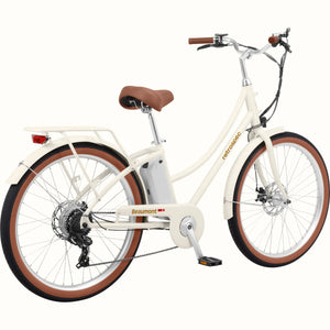Retrospec Beaumont Rev 3 electric bike in eggshell color, side view, featuring step-through frame, rear rack, and brown saddle and grips.
