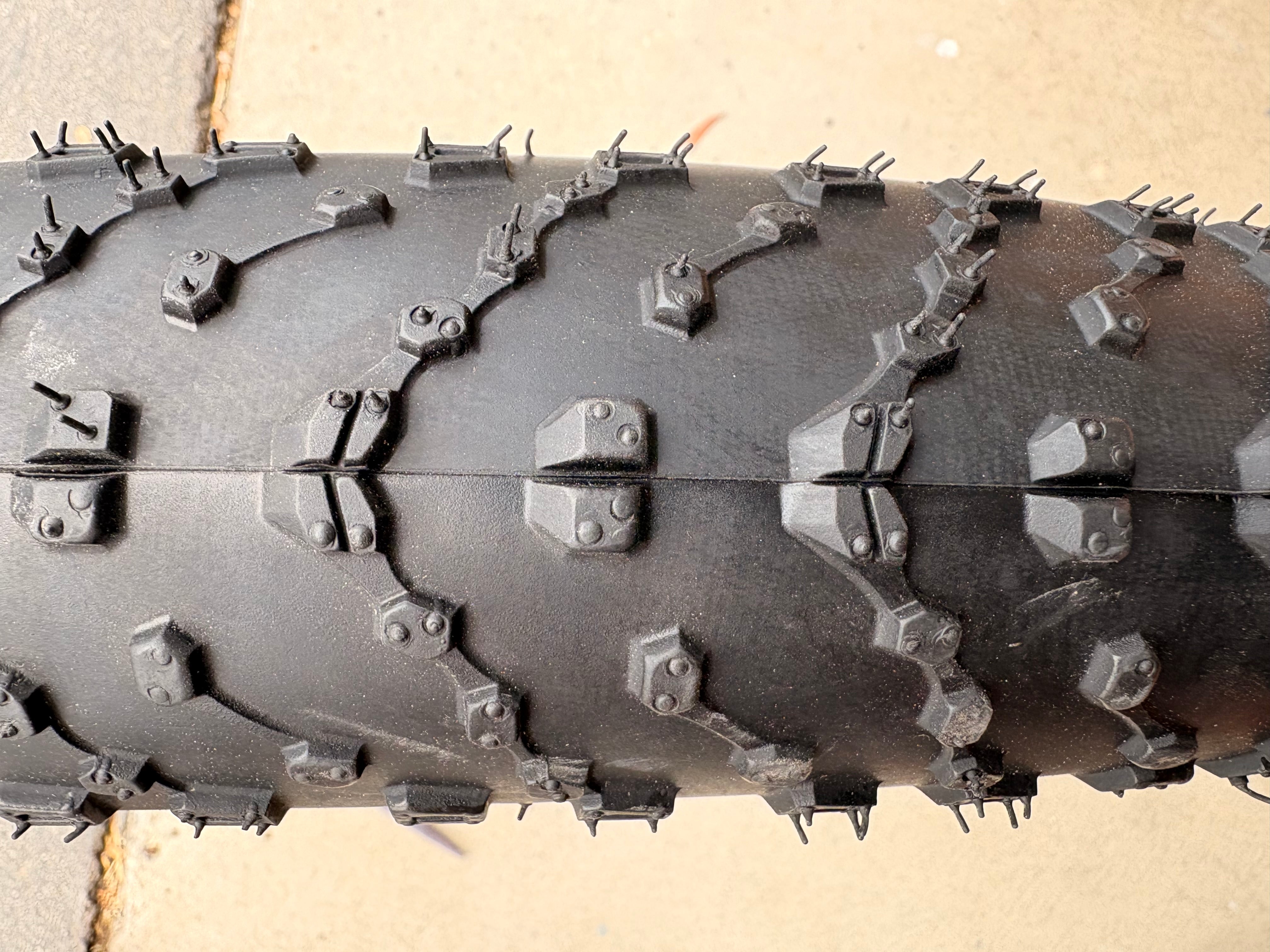 A black eBike with 26x4 inch Kenda Juggernaut fat tires, shown in a side profile against a white background.