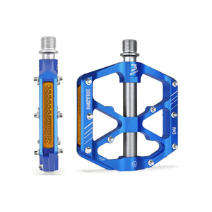 Blue alloy bicycle pedals with built-in reflectors, shown from a side angle.