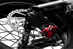 A black eMOTO Segway Xyber electric bike parked outdoors on a paved surface, showcasing its rugged frame, thick tires, and modern design.
