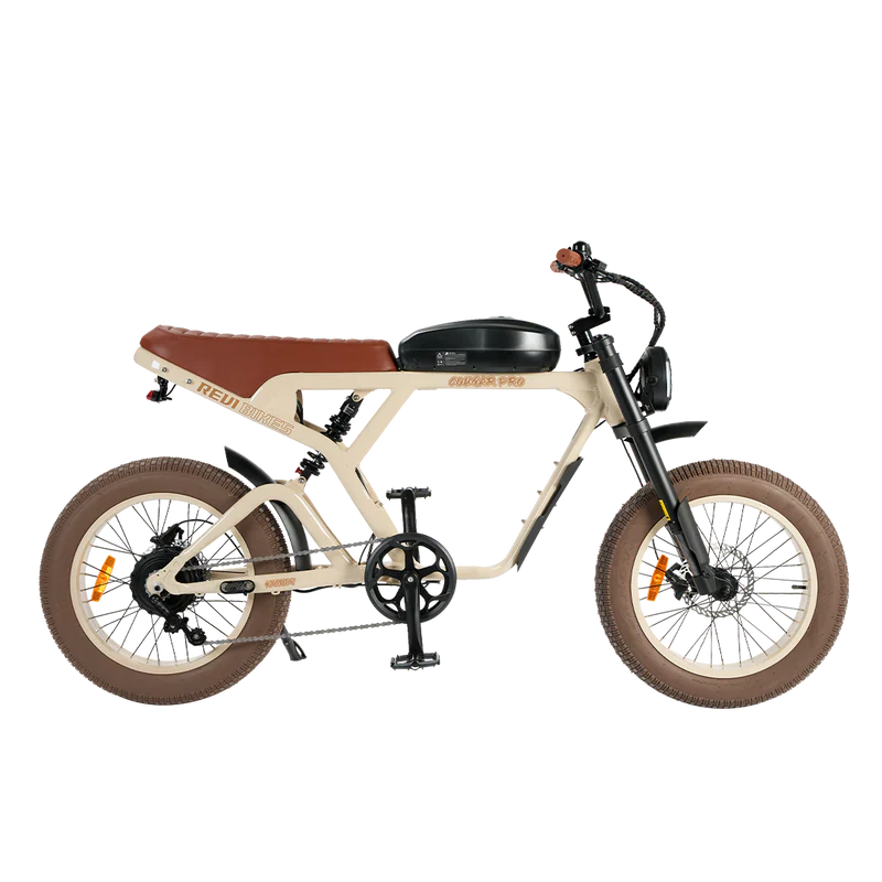 Side view of the eMOTO eBike Revi Cougar Pro in sand color, showcasing its sturdy frame, fat tires, and integrated battery on a plain background.