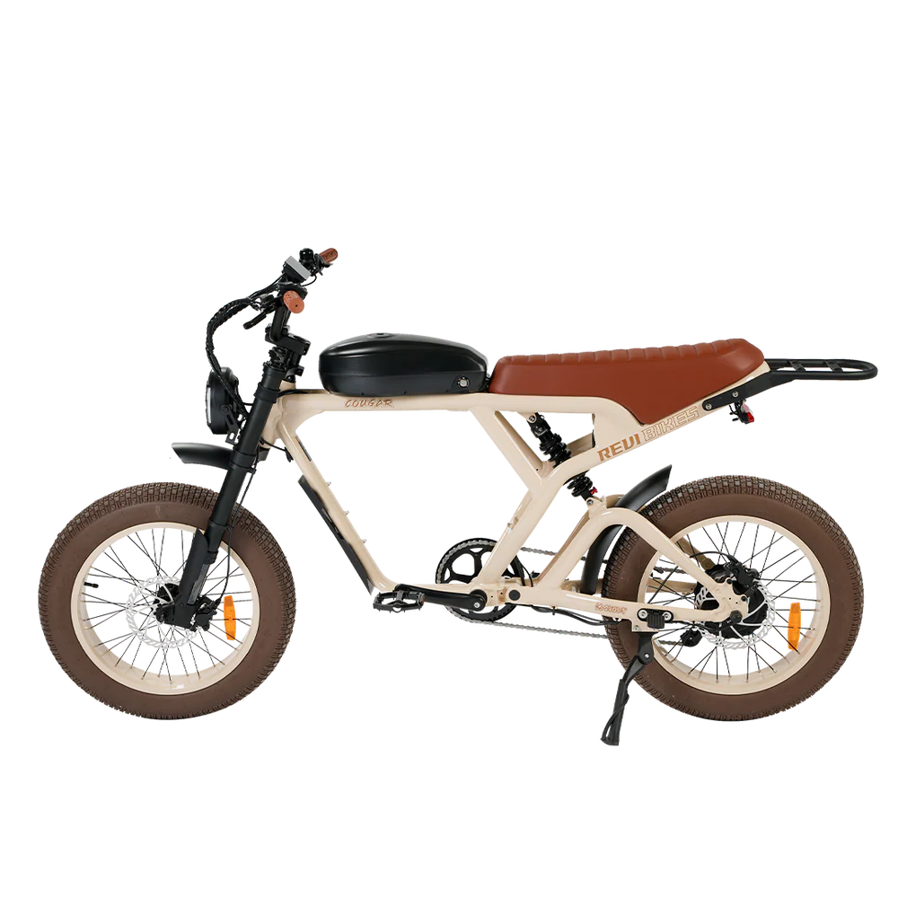 Side view of the eBike Revi Cougar in sand color, showing its frame, wheels, and battery on a white background.