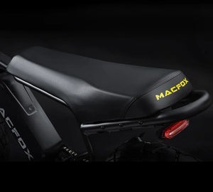 Side view of the Macfox X7 eBike in a studio setting, showcasing its black frame, thick tires, front suspension fork, and ergonomic seat.
