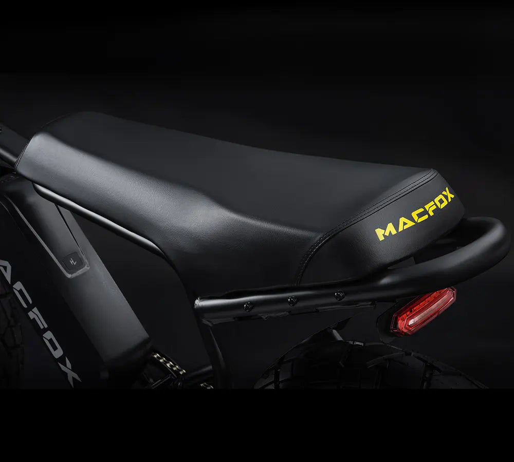 Side view of the Macfox X7 eBike in a studio setting, showcasing its black frame, thick tires, front suspension fork, and ergonomic seat.