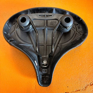 A black eBike seat in a beach cruiser style with a wide, cushioned design and smooth, contoured surface, shown against a plain background.