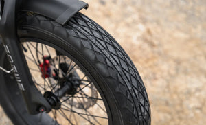 Engwe M20 3.0 electric bike in matte black, shown from a side angle with thick tires, dual headlights, and a sturdy frame, parked on a paved surface.