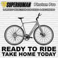 A sleek e-bike, the Superhuman Photon Pro, in Liquid Titanium color, shown from a side angle highlighting its modern frame, integrated battery, and advanced components.