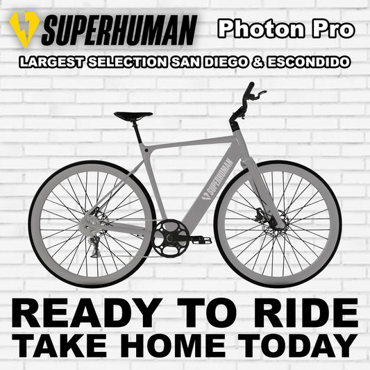 A sleek e-bike, the Superhuman Photon Pro, in Liquid Titanium color, shown from a side angle highlighting its modern frame, integrated battery, and advanced components.
