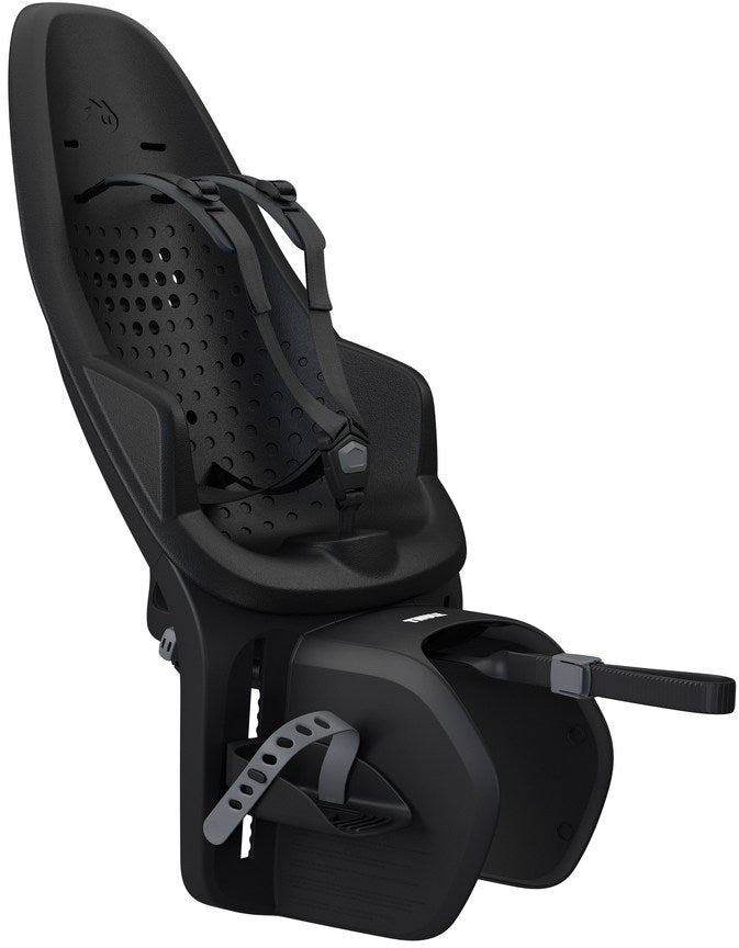 A black Thule Yepp 2 Maxi baby seat securely mounted on the rear rack of an eBike, shown from a side angle.