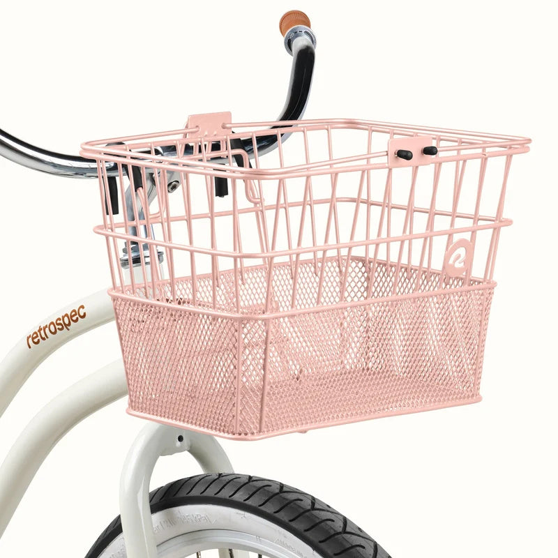 Blush pink Retrospec Apollo steel bike basket attached to the front of an eBike