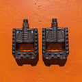 Folding nylon eBike pedals in black, shown in a partially folded position against a white background.