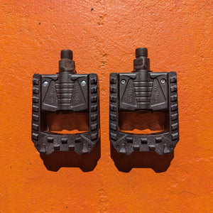 Folding nylon eBike pedals in black, shown in a partially folded position against a white background.