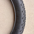 A black eBike with 26x4 inch Kenda Krusade fat tires, shown in a side profile against a white background.