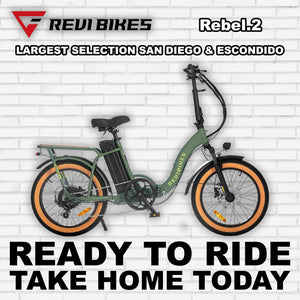 A wild green eBike Revi Rebel.2 R2R electric bicycle, side view, showcasing its sturdy frame, fat tires, and modern design.