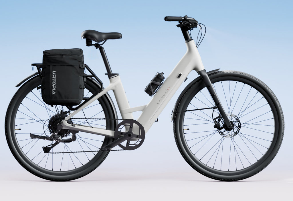 Side view of the Urtopia Carbon 1 Step Thru eBike in creme color, showcasing its lightweight carbon frame, step-through design, and sleek modern styling against a plain background.