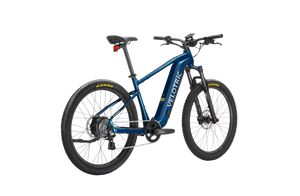 Royal blue Velotric Summit 1 eBike side view, showcasing frame design, wheels, and handlebars against a plain background.