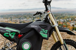 Side view of the eMOTO eBike Drift Hero 1600w dirt bike in black and green, showcasing its rugged tires, sturdy frame, and off-road design features.