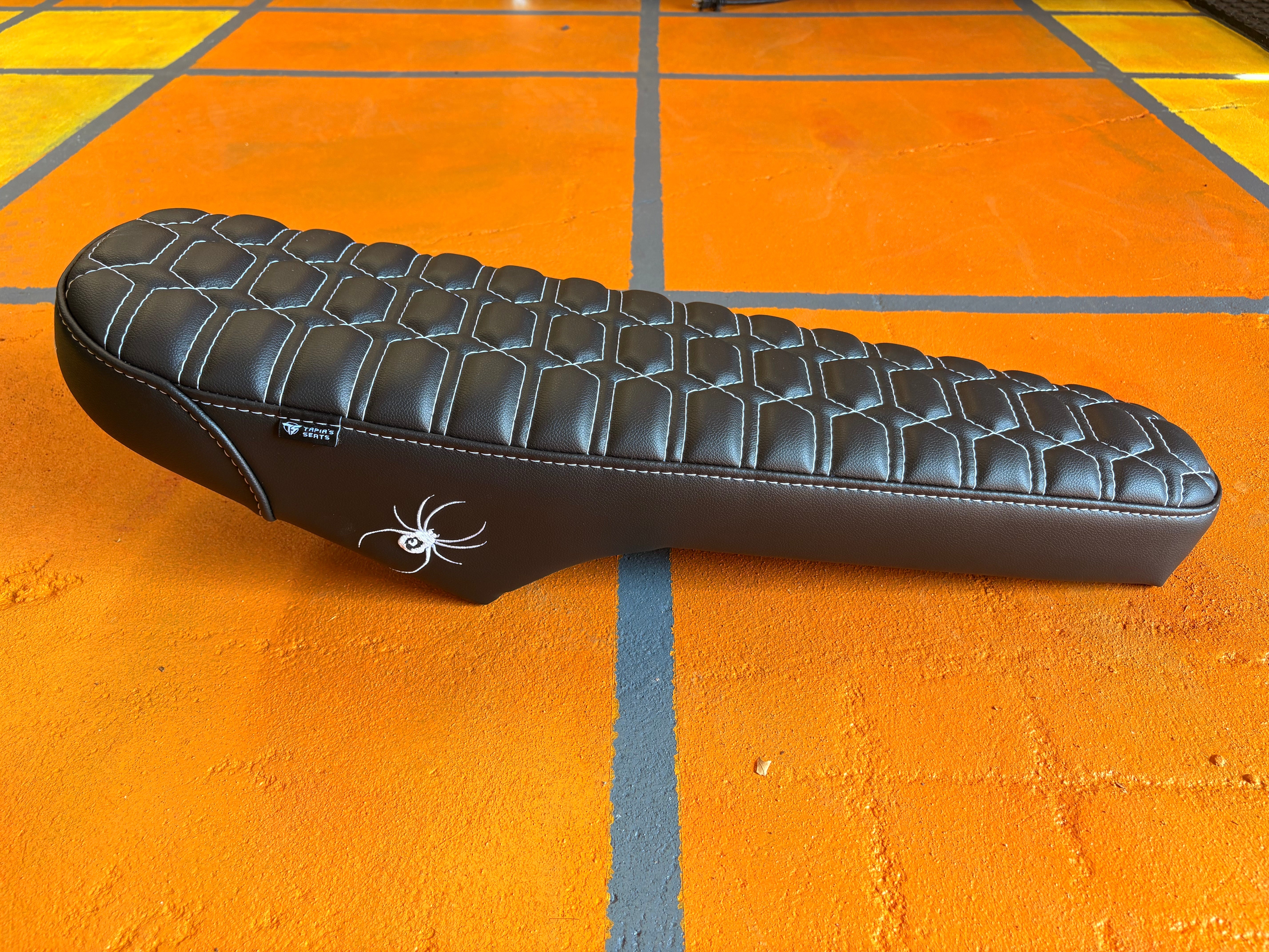 eMOTO eBike Seat in MOTO style, GhostCat white and black color, product image showing black seat with white accents