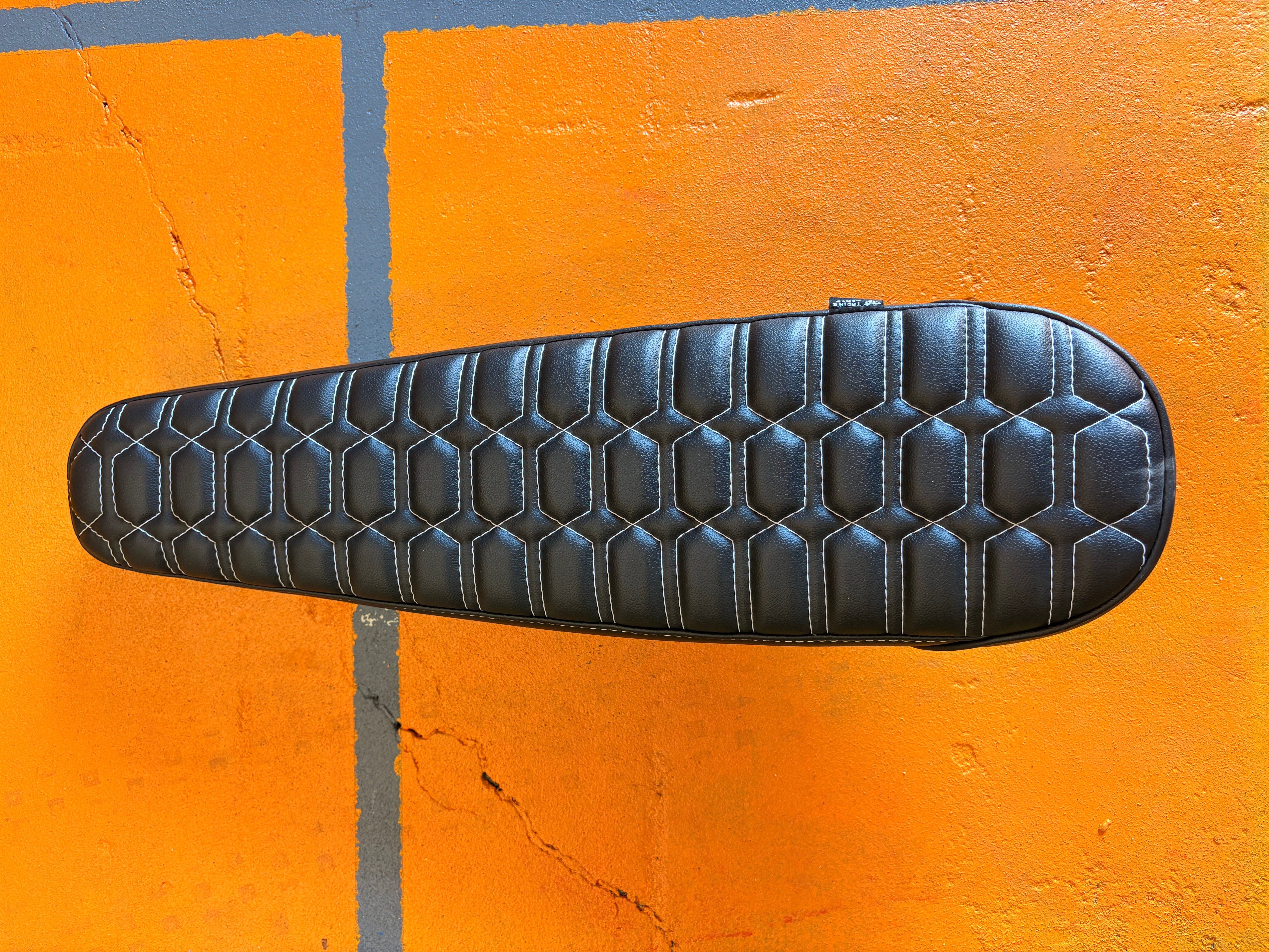 eMOTO eBike seat in MOTO style, GhostCat white and black color, product image showing black seat with white accents