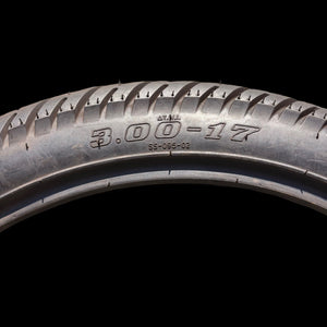 eMOTO Vuro Star 3.00-17 17-inch tire, side view, black tread with visible branding
