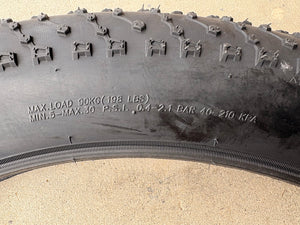 A black eBike with 26x4 inch Kenda Juggernaut fat tires, shown in a side profile against a white background.