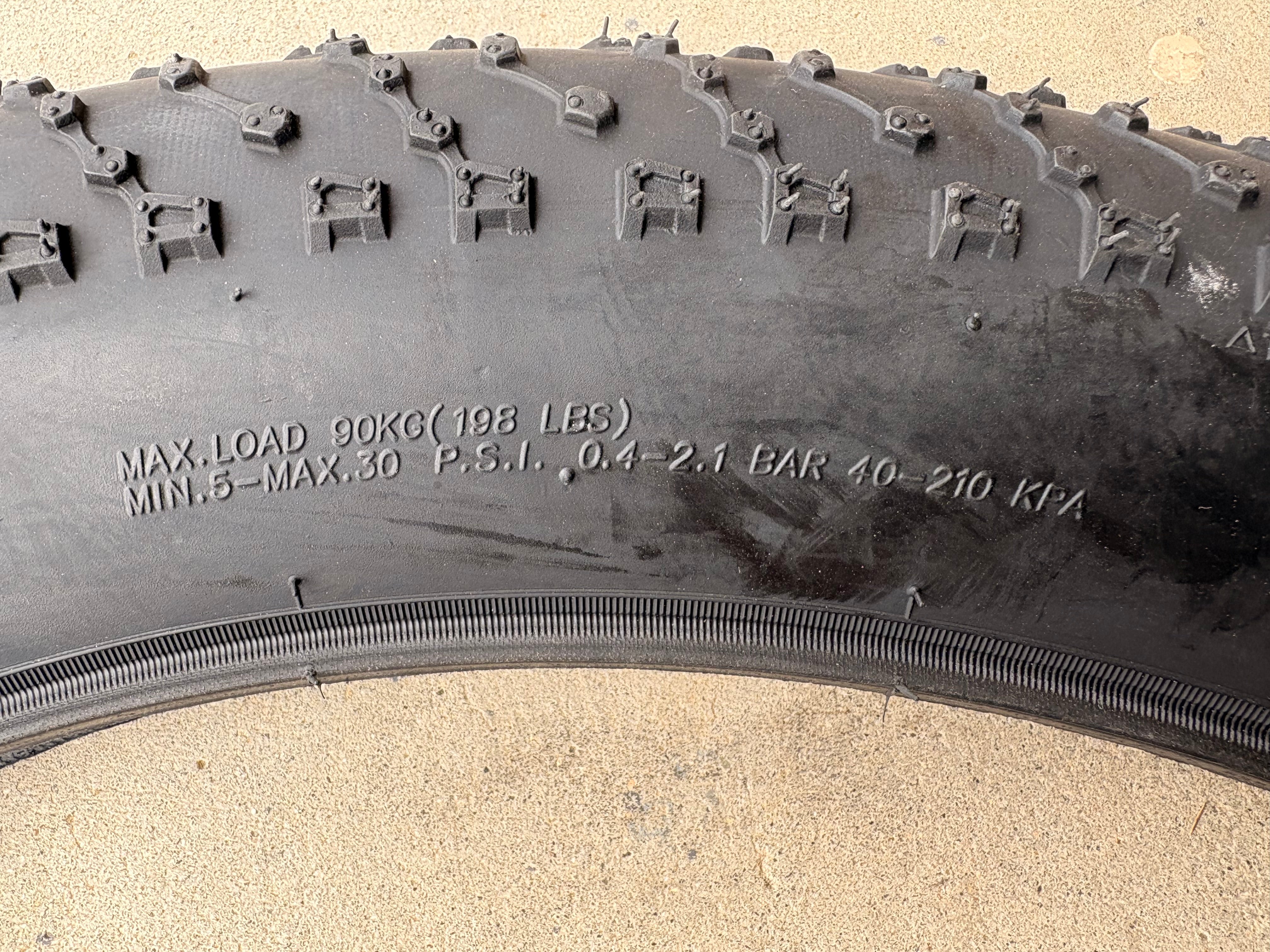 A black eBike with 26x4 inch Kenda Juggernaut fat tires, shown in a side profile against a white background.